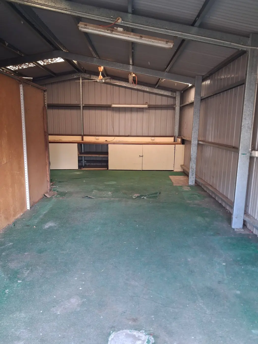 The same shed stripped out to a bare, empty floor
