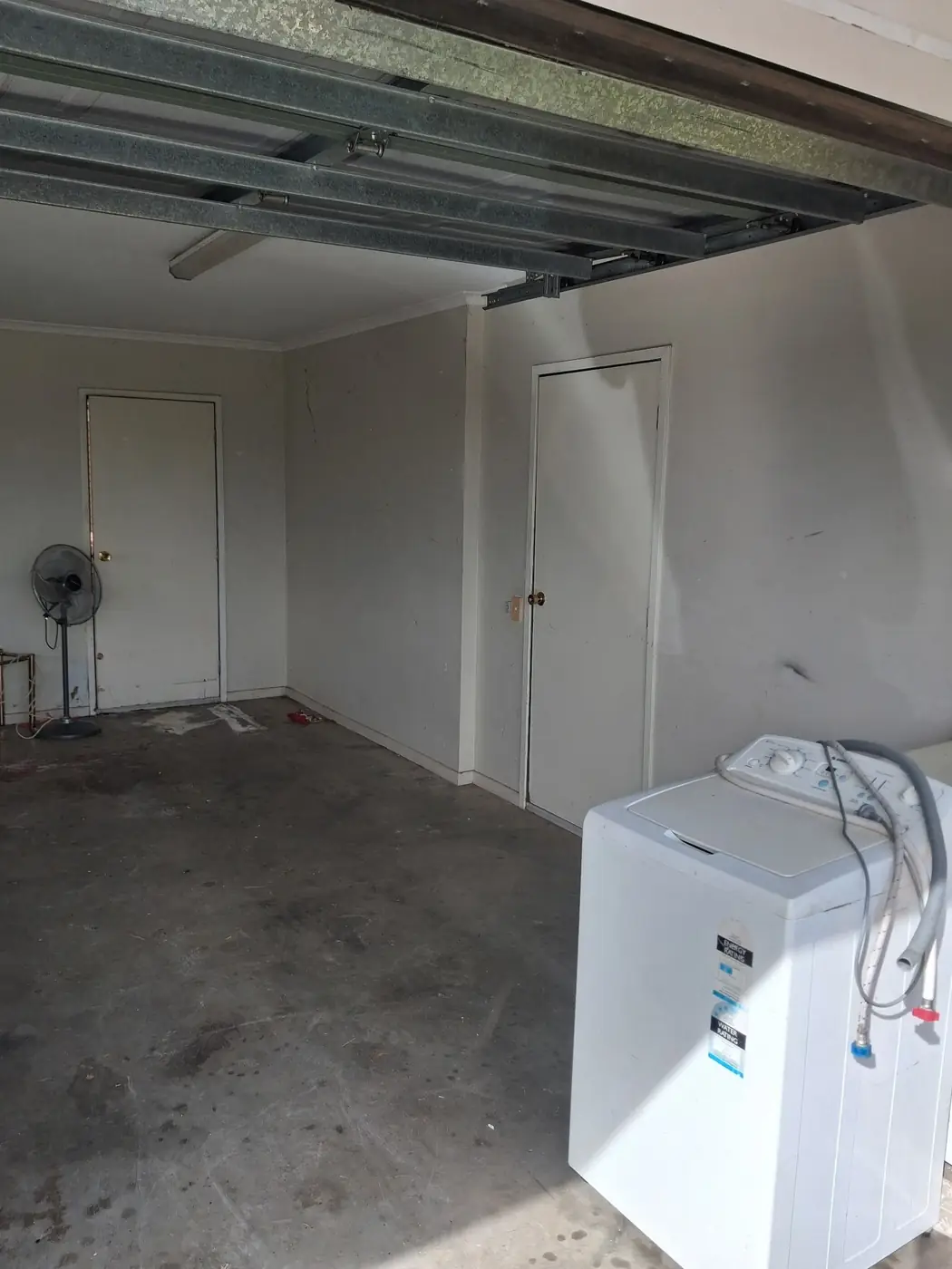The same garage cleared out, with only the washing machine left in place